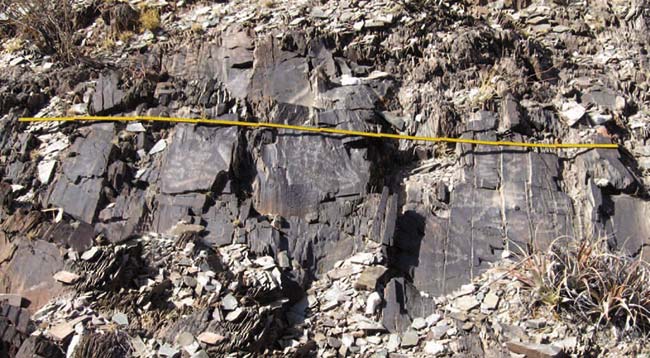 Rocas o afloramientos en que están grabados los motivos, diseminados a lo largo de unos 3km de la ladera oriental de la quebrada. Cada tramo del metro de carpintero que da la escala mide 20cm (en total 2m).