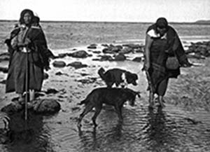 Mujeres selk’nam con perros en la costa fueguina, 1923. Foto Alberto María De Agostini, archivo Asociación de Investigaciones Antropológicas.